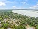 Stunning aerial perspective of the lakeside neighborhood's homes nestled among lush trees against a partly cloudy sky at 1161 Cr 443, Lake Panasoffkee, FL 33538