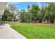 Expansive backyard with a spacious lawn and mature trees, creating a serene outdoor retreat at 1161 Cr 443, Lake Panasoffkee, FL 33538
