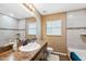 Bathroom with dark cabinets, decorative mirror, tiled shower, and neutral color scheme at 1161 Cr 443, Lake Panasoffkee, FL 33538