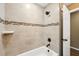 Bathroom featuring neutral tile, a shower/tub, and shower door leading to a beige-colored room at 1161 Cr 443, Lake Panasoffkee, FL 33538