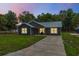 Charming single-story home featuring a metal roof, dark siding, and a well-manicured lawn, perfect for modern living at 1161 Cr 443, Lake Panasoffkee, FL 33538