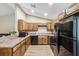 Charming kitchen featuring warm wood cabinets, stone countertops, and modern black appliances at 1161 Cr 443, Lake Panasoffkee, FL 33538