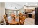 Well-lit kitchen and dining area with wood cabinets, black appliances, and an open layout, ideal for entertaining at 1161 Cr 443, Lake Panasoffkee, FL 33538