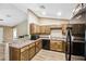 Charming kitchen featuring warm wood cabinets, stone countertops, and modern black appliances at 1161 Cr 443, Lake Panasoffkee, FL 33538