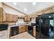 Charming kitchen featuring warm wood cabinets, stone countertops, and modern black appliances at 1161 Cr 443, Lake Panasoffkee, FL 33538