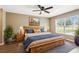 Bright main bedroom with a large bed, ceiling fan, and a window offering a pleasant view at 1161 Cr 443, Lake Panasoffkee, FL 33538