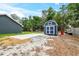 Backyard with a new shed, concrete pad and gravel, perfect for outdoor projects and storage at 1161 Cr 443, Lake Panasoffkee, FL 33538