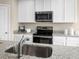 Modern kitchen featuring granite countertops, stainless steel appliances, and white cabinets and an island sink at 1548 Covey Rise Ter, Winter Haven, FL 33884