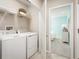 Well-equipped laundry room with modern washer and dryer and ample shelving at 1548 Covey Rise Ter, Winter Haven, FL 33884