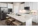 Bright kitchen with stainless steel appliances and white cabinets, with an island and seating at 2193 Aibonito Cir, Clermont, FL 34711