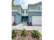 Charming townhome showcasing well-maintained landscaping, two-car garage, and inviting front entrance at 5232 Luisa Ct, St Cloud, FL 34771