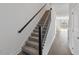 Carpeted staircase featuring wood handrail and black metal spindles at 1096 Desert Candle Dr, Ocoee, FL 34761