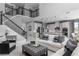 Open-concept living room featuring a staircase to the second floor and kitchen view at 136 Venetian Palms Blvd, New Smyrna Beach, FL 32168
