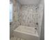 Renovated bathroom featuring marble tile, white tub and updated fixtures at 2827 Se 2Nd St, Ocala, FL 34471