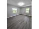 Bedroom featuring gray walls, hardwood flooring, and two windows providing ample light at 2827 Se 2Nd St, Ocala, FL 34471