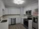 Bright kitchen with stainless steel appliances, gray cabinets, and wood-look flooring at 2827 Se 2Nd St, Ocala, FL 34471