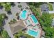 Aerial view of community swimming pools, parking, lush greenery and palm trees enhance this outdoor oasis at 8596 Sw 108Th Place Rd, Ocala, FL 34481