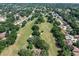 Aerial view of the golf course showcasing green space, mature trees, and residences in the surrounding community at 8596 Sw 108Th Place Rd, Ocala, FL 34481