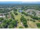 An aerial view of the community showcasing an expansive golf course and pond amid lush trees and homes at 8596 Sw 108Th Place Rd, Ocala, FL 34481