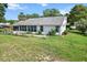 Rear view of a home with a cozy screened-in porch, landscaped yard, and a well-maintained lawn at 8596 Sw 108Th Place Rd, Ocala, FL 34481