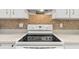 Close-up of the Samsung cooktop with white cabinets and a mosaic backsplash creating a clean and functional cooking space at 8596 Sw 108Th Place Rd, Ocala, FL 34481