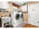 Functional laundry room with a utility sink, washer, dryer and upper cabinets at 8596 Sw 108Th Place Rd, Ocala, FL 34481