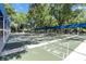 Enjoy shuffleboard on these multiple green courts that are sheltered from the sun by a blue awning, surrounded by trees at 8596 Sw 108Th Place Rd, Ocala, FL 34481