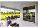 Covered patio with dining and lounge area, overlooking a lush green lawn and pond at 1204 Ivy Manor St, Minneola, FL 34715