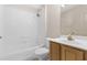Bathroom with white tile, a shower-tub combo and patterned wallpaper at 1424 Figueroa St, The Villages, FL 32162