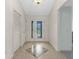 Bright foyer featuring tile flooring, a decorative glass front door, and white walls at 1424 Figueroa St, The Villages, FL 32162