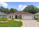 Charming single-story home featuring manicured landscaping and a paver driveway at 1424 Figueroa St, The Villages, FL 32162