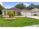 Exterior of house with palm trees, rock garden and decorative driveway at 1424 Figueroa St, The Villages, FL 32162