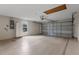 View of the two car garage with painted floor, white storage cabinet, and automatic door at 1424 Figueroa St, The Villages, FL 32162