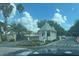 Community's gatehouse, offering controlled access with a visitor's entrance, an American flag, and lush tropical landscaping at 1424 Figueroa St, The Villages, FL 32162