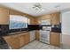 Kitchen featuring oak cabinets, granite countertops, and white appliances at 1424 Figueroa St, The Villages, FL 32162