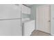 Laundry room with tiled floor, washer and dryer, white cabinets, and refrigerator at 1424 Figueroa St, The Villages, FL 32162
