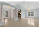 Open-concept living room with tile flooring, decorative pillars, and chandelier lighting at 1424 Figueroa St, The Villages, FL 32162