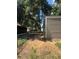 Exterior view of the home's backyard with a metal gate and utility buildings at 3346 Se 131St Pl, Belleview, FL 34420