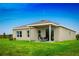 Expansive backyard featuring a covered patio with outdoor seating, ideal for relaxation and entertaining at 454 Hammock Oaks Blvd, Lady Lake, FL 32159