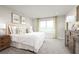 A bright bedroom featuring neutral colors and an airy aesthetic with a large window overlooking the landscape at 454 Hammock Oaks Blvd, Lady Lake, FL 32159