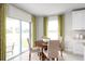 Cozy breakfast nook with a round table, four chairs, sliding glass doors and lots of natural light at 454 Hammock Oaks Blvd, Lady Lake, FL 32159