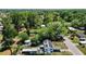 An aerial view of a home with solar panels, shed, and above-ground pool surrounded by lush greenery at 801 Nw 16Th Ct, Ocala, FL 34475