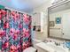 The bathroom includes a floral shower curtain, a mirror, and a white vanity with sink at 801 Nw 16Th Ct, Ocala, FL 34475