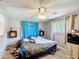 This bedroom features light-gray walls, carpet, a ceiling fan, two small wall shelves, and two windows at 801 Nw 16Th Ct, Ocala, FL 34475