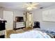 This bedroom features light-gray walls, carpet, a ceiling fan, a TV, and a large dresser at 801 Nw 16Th Ct, Ocala, FL 34475