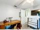 This bedroom features a desk, dresser, and ceiling fan. The light-gray walls provide a neutral backdrop at 801 Nw 16Th Ct, Ocala, FL 34475