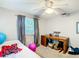 This bedroom features a desk, ceiling fan, light-gray walls, carpet, and a window with dark curtains at 801 Nw 16Th Ct, Ocala, FL 34475