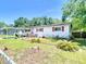 Charming single-story home with red shutters, solar panels, a carport, and fenced front yard at 801 Nw 16Th Ct, Ocala, FL 34475