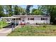 Charming single-story home with red shutters, solar panels, a carport, and fenced front yard at 801 Nw 16Th Ct, Ocala, FL 34475