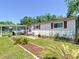 Charming single-story home with red shutters, solar panels, a carport, and fenced front yard at 801 Nw 16Th Ct, Ocala, FL 34475